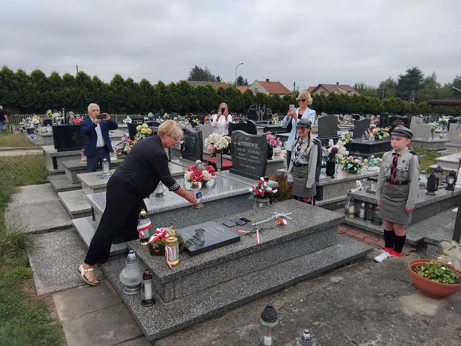 Cecylia Radoń składa znicz na grobie