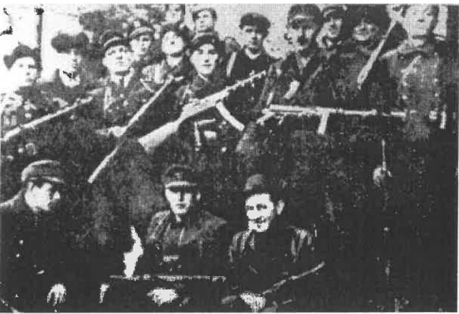 Partyzanci oddziału AK „Huta-Podgórze” pod koniec 1944 r. U dołu siedzą od lewej: sierż. Henryk Ostruszka „Wicher”, dowódca oddziału por. Paweł Dyrbuś „Grom”, dowódca plutonu por. Stanisław Marek „Podbipięta”. Stoją od lewej: szef kompanii ppor. Józef Szczybura „Ryś”, NN „Lew” (być może sierż. Ludwik Górny „Leo”), kpr. Jan Tomaszek „Szczapa”, jego brat „Jastrząb”, NN, NN „Zając”, NN „Ryś”, Lik von Neue „Lik”, plut. Mieczysław Hilarowicz „Achilles”, st. strz. Jan Flaka „Sojka”, kpr. Józef Juraszek „Borsuk”. Fot. Z. Walter-Janke, „W Armii Krajowej w Łodzi i na Śląsku”, Warszawa 1969