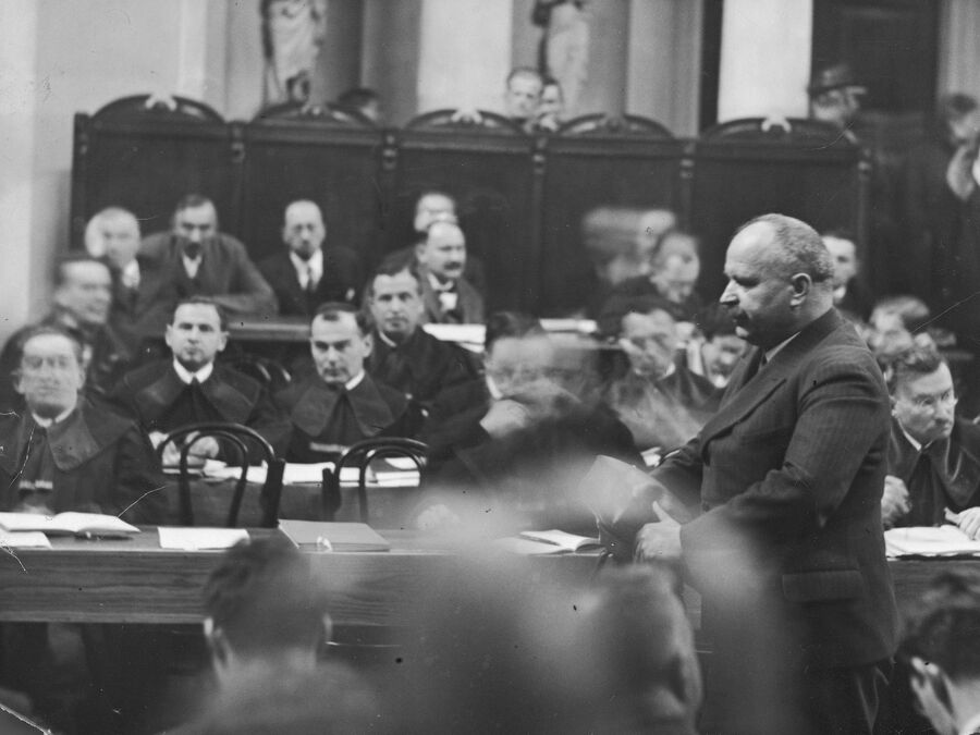 Przed sądem zeznaje Mieczysław Mastek (PPS). W tle widoczna ława oskarżonych procesu brzeskiego z widocznymi m.in. Wincentym Witosem i Władysławem Kiernikiem z PSL „Piast” (źródło: NAC)