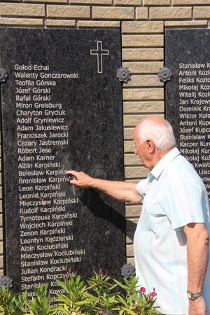 Czesław Karpiński wskazuje nazwisko swego ojca na tablicy upamiętniającej poddanych represjom komunistycznym Polaków z Dołbysza