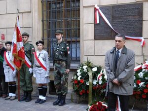 Śp. Janusz Kurtyka przed tablicą upamiętniającą ofiary procesu krakowskiego