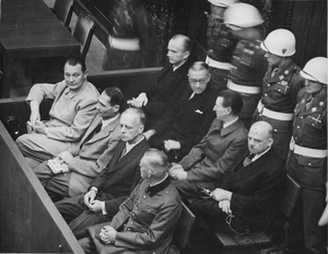 Ława oskarżonych w Norymberdze. W pierwszym rzędzie: Göring, Hess, Ribbentrop, Keitel; w drugim: Dönitz, Raeder, Schirach, Sauckel